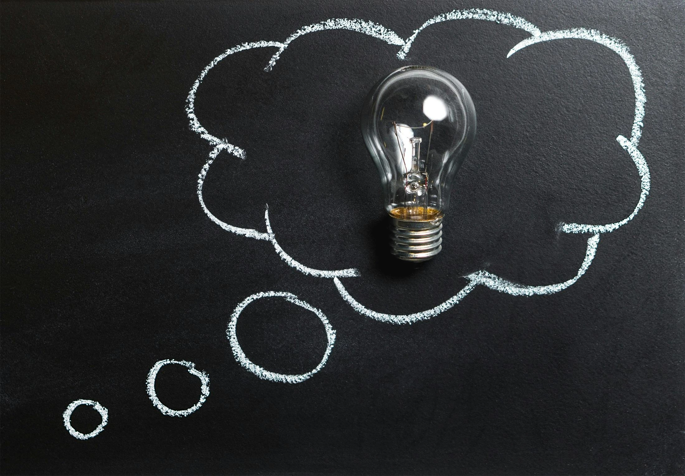 Light bulb inside a chalk-drawn thought bubble, symbolizing ideas and creativity for a national level competition