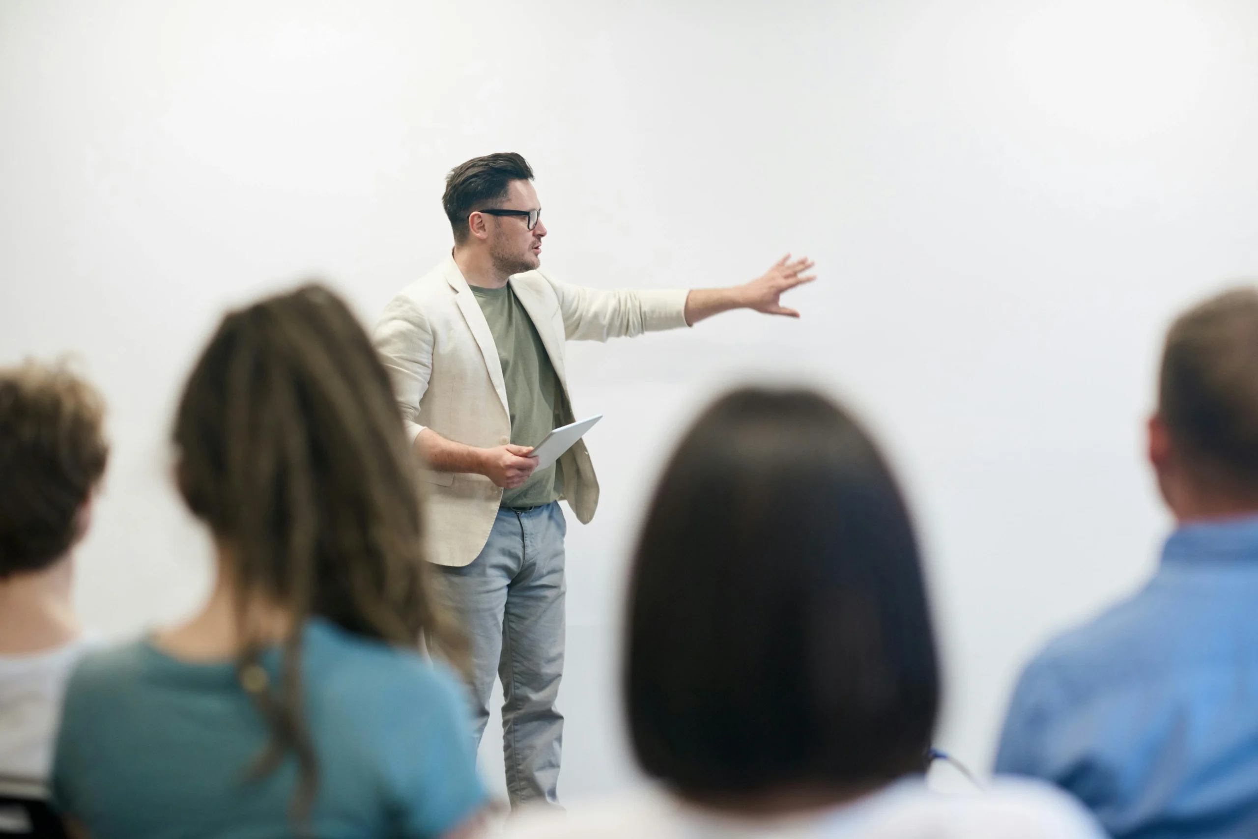 Man confidently speaking to an audience in a classroom setting, representing how to overcome social anxiety through public speaking and self-confidence