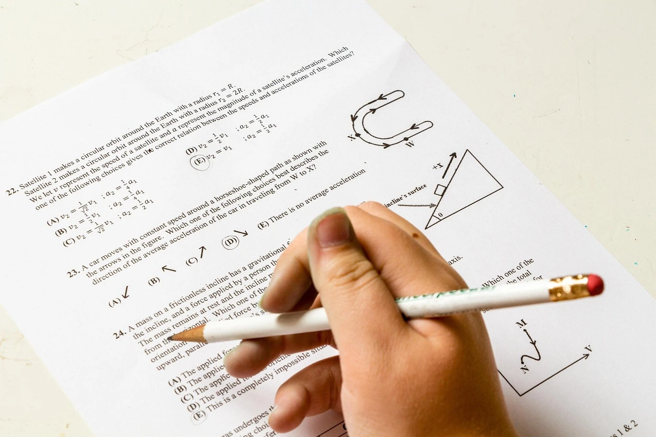 Student solving physics or math multiple-choice questions with a pencil during maths olympiad.