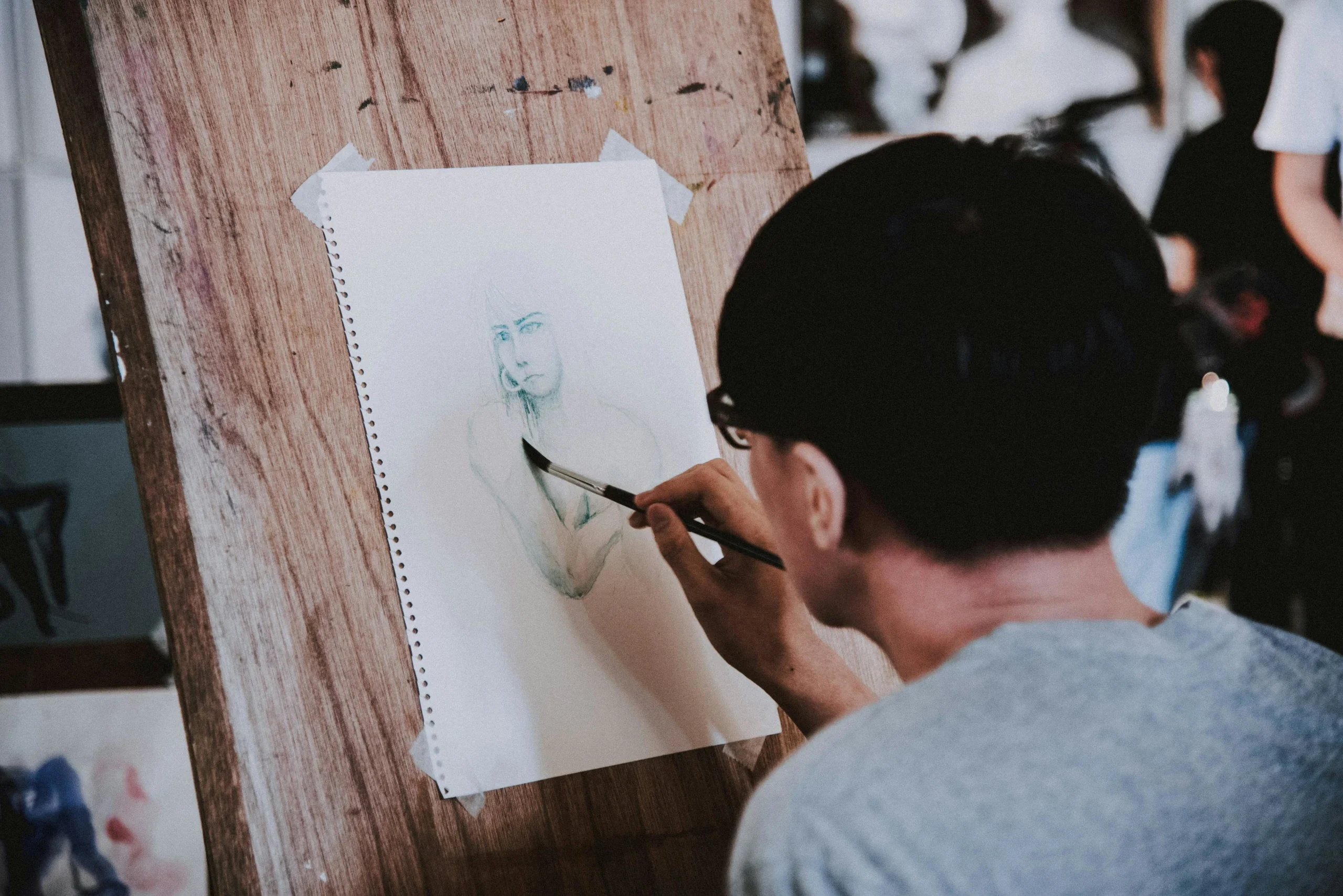 Child sketching a portrait on paper during an Online Drawing Competition for Kids.